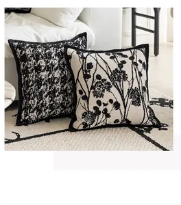 Close-up of two black and white decorative throw pillow covers on a modern living room rug
