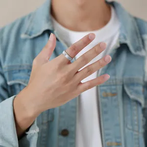 Detailed view of a silver faceted tungsten steel ring worn on a man's hand