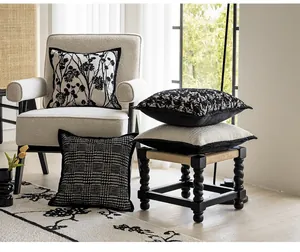 Elegant black and white vintage cushion covers displayed in a cozy living room setting.