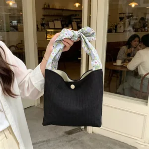 Chic literary black handbag featuring vertical stripes and a cute floral bow handle