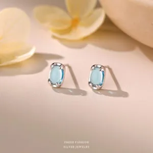 Macro detail of S999 sterling silver stud earrings with light blue oval zircon stones