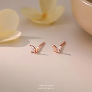 Macro view of dainty rose gold butterfly stud earrings with sparkling crystals