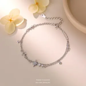 Close-up of double-layer silver bracelet featuring shimmering star charms and zircons.