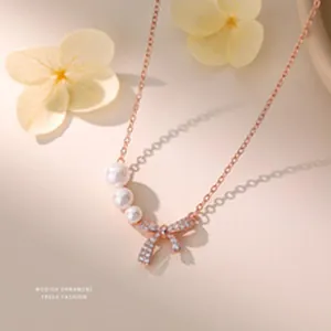 Close-up of elegant s999 sterling silver necklace with zircon bow and pearl pendant