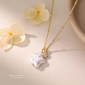 Close-up of elegant gold necklace with star-shaped pearl and zircon pendant