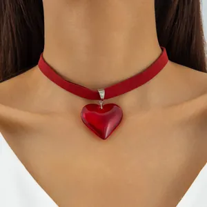 Detailed view of a Gothic red glass heart pendant on a red velvet choker necklace.