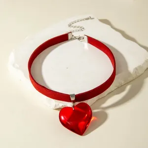 Close-up of a Gothic red velvet choker featuring a large translucent glass heart pendant.