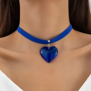 Close-up of gothic blue heart glass pendant on a blue velvet choker necklace