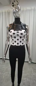 Détail du haut de yoga licou à pois et des leggings noirs sur un mannequin chromé