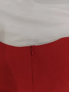 Close-up view of invisible back zipper on red and white sleeveless dress detail.