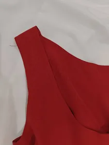Close-up of elegant red sleeveless dress neckline showing the fine fabric texture