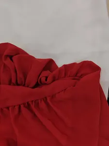 Macro view showing the high-quality red fabric texture and ruffle detail of this dress