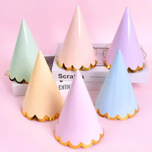 Set of six pastel cone party hats with gold scalloped trim for kids birthday decor.