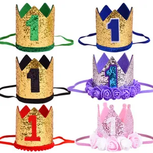 Detailed view of assorted glittery first birthday crown hats for kids' party decorations