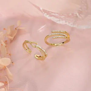 Detail view of two gold geometric open rings with sparkling micro-pave crystals.
