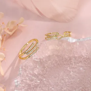 Close-up detail of two gold-finish geometric rings with cubic zirconia pavé details.