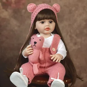 Realistic reborn baby doll in pink knitted outfit with cute bear hat and companion bear