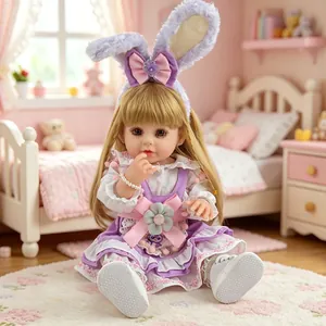 Realistic reborn baby doll in purple bunny outfit sitting in pink miniature bedroom