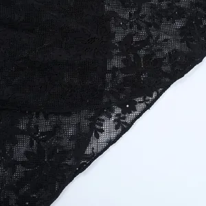 Detaillierte Makroaufnahme von feinem schwarzem Blumen-Spitzenstoff mit Textur
