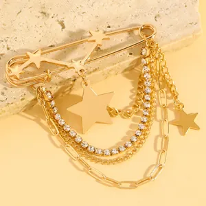 Detailed macro view of gold safety pin brooch with layered chains and star charms