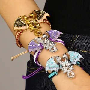 Detail van vintage geweven drakenarmbanden met kleurrijke geëmailleerde vleugels