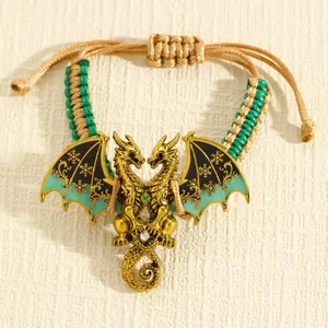 Detailweergave van een retro gouden drakenarmband met groenblauw email en gevlochten touw.