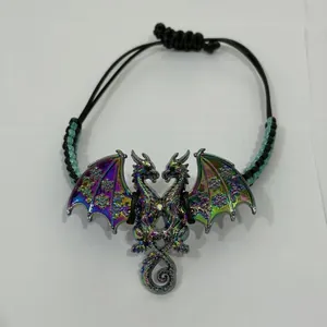 Detailopname van de kleurrijke emaille draakhanger met vleugels aan een gevlochten armband