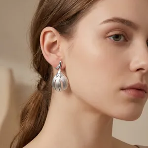 Close-up of vintage leaf stainless steel earrings with a textured silver finish