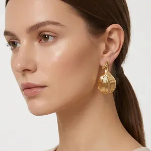 Close-up of gold vintage leaf-shaped earrings worn on a model's ear