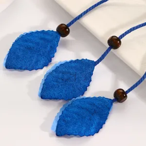 Detail of Bohemian ethnic waist rope featuring blue fabric leaves and wooden beads