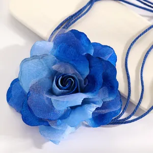 Detailed view of a large blue gradient fabric rose with woven cords for dress belts.