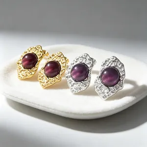 Detailed view of French vintage cat's eye earrings with textured irregular gold and silver frames
