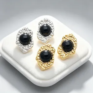 Close-up of vintage irregular 18K gold plated earrings with black cat's eye stones