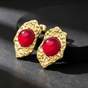 Macro detail of French vintage 18K gold plated earrings with red cat's eye stones