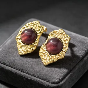 Close-up of French vintage 18K gold-plated irregular earrings with red cat eye stone