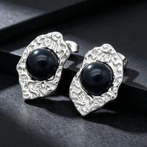 Detailed view of French retro irregular silver earrings with black stone inlay.