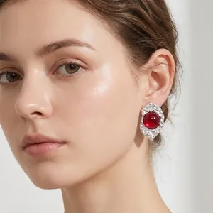 Close-up of a model wearing retro irregular silver earrings with a red stone center