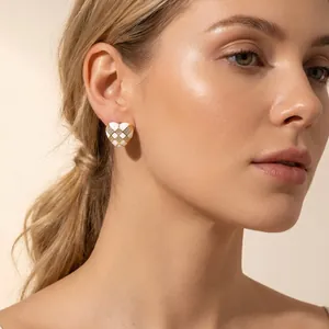 Close-up view of elegant heart-shaped checkerboard earrings with inlaid diamonds on a model