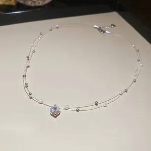 Gros plan élégant d'un collier ras du cou minimaliste à deux couches avec perles et zircone