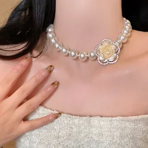 Gros plan d'un collier de perles élégant avec un pendentif rose orné de cristaux brillants.