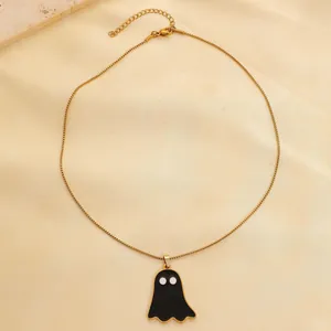Close-up of a gold stainless steel necklace with a black and white ghost pendant