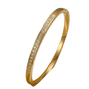 Elegante bracciale rigido in acciaio al titanio dorato con brillanti cristalli intarsiati