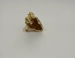 Detailansicht einer kreativen goldfarbenen Straußbrosche mit einer hohlen Struktur