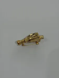 Detaillierte Makroansicht der goldenen Bouquet-Brosche mit einer Faltenmetall-Textur
