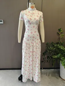 Detailed view of elegant white French maxi dress featuring pink rose print and slim waist.