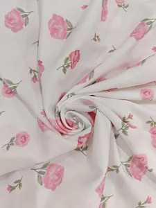 Macro view of elegant pink rose floral print on soft white fabric of a French dress