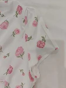 Close-up of pink rose floral pattern on a white French style summer dress sleeve detail