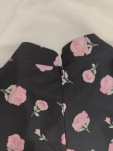 Close-up detail showing back hidden zipper and pink rose pattern on elegant French dress