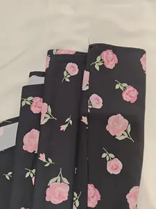 Detail of black fabric with elegant pink rose floral prints for a French style dress