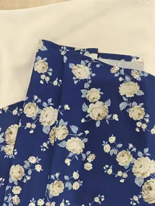 Close-up view of the elegant blue floral print fabric on a vintage French style dress